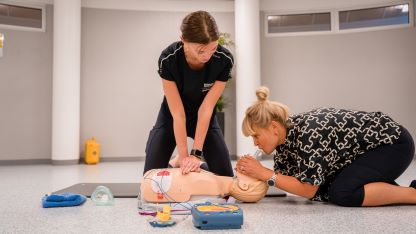 Två personer som utför HLR på en docka.